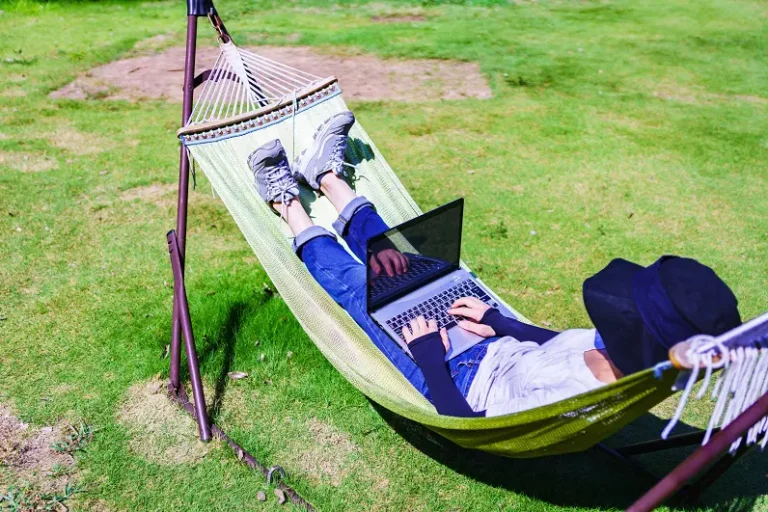 kid relaxing in hammock using internet